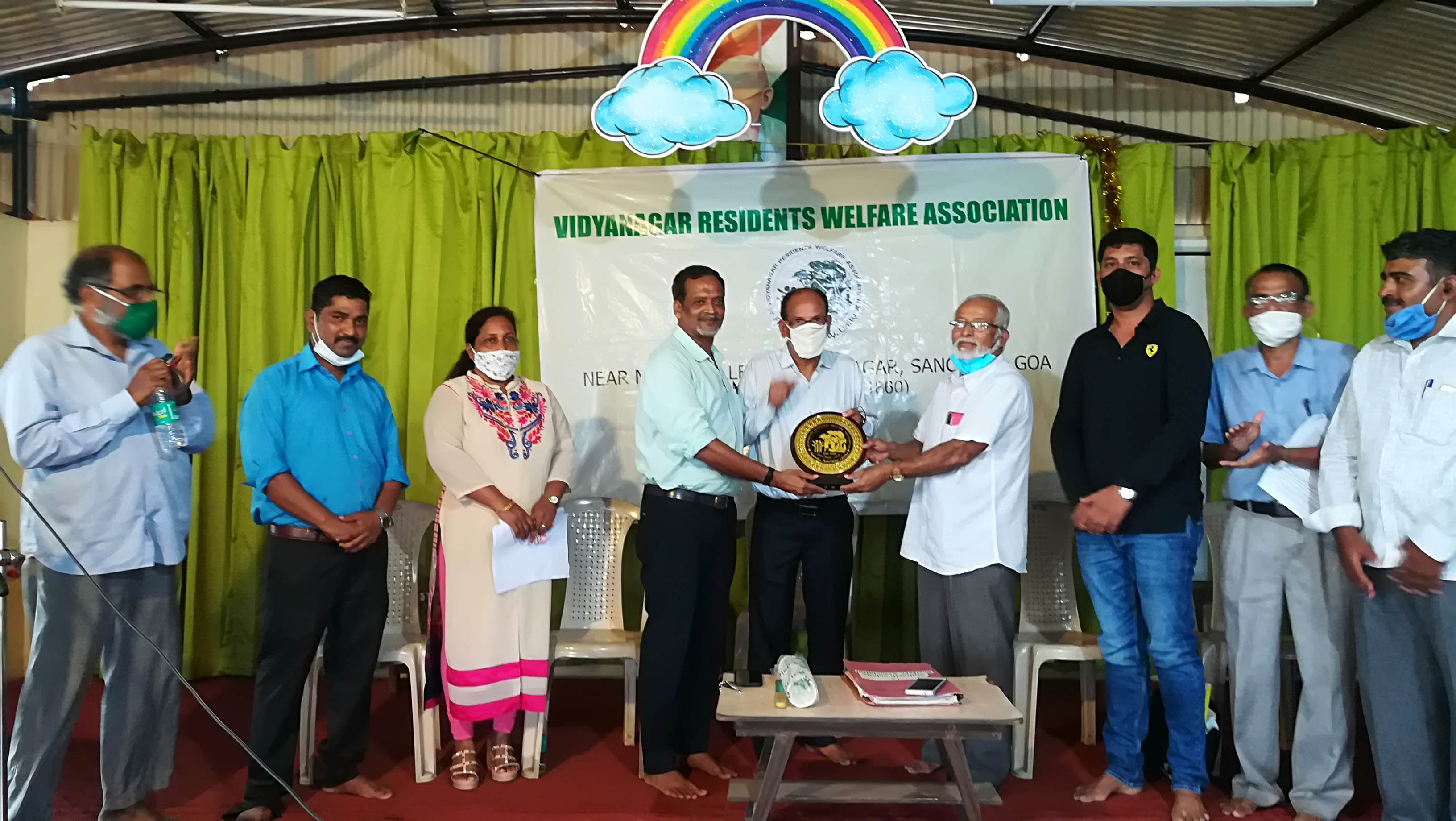 Association Logo in the form of a memento being presented to the Association President Shri Santosh Desai by the outgoing President Shri Eddie Fernandes and Founder member Shri Cherian Kuruvilla.

Seen on the stage from left: Mr. Rafik Shaikh Issak (Co-opted member), Mrs. Luiza Correia (Executive member), Shri Ganesh Lamani  (Secretary), Shri Eddie Fernandes, Shri Santosh Desai, Shri Cherian Kuruvilla, Shri Sagar Toraskar (Joint Secretary), Shri Shantaram Desai (Treasurer) and Shri Monish Meti (Co-opted member).