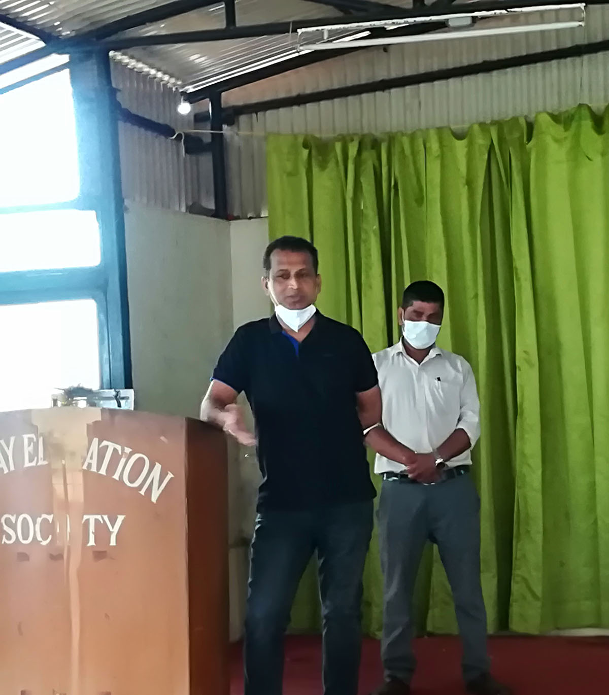 Vidyanagar Association Vice-President and ex-student of Airway Public School Shri Surendra Naik, seen addressing the gathering on occasion of the felicitation of the principal and teachers of Airway Public School on their securing 100% results during the 2020 SSC examination. Also seen in the background is Vidyanagar Association Secretary, Shri Ganesh Lamani.