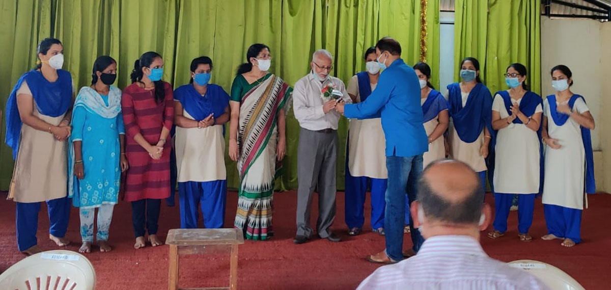 Shri Avinash Tulaskar (in blue) felicitating the principal Mr. Cherian Kurvilla on his School securing 100% results in SSC exams.