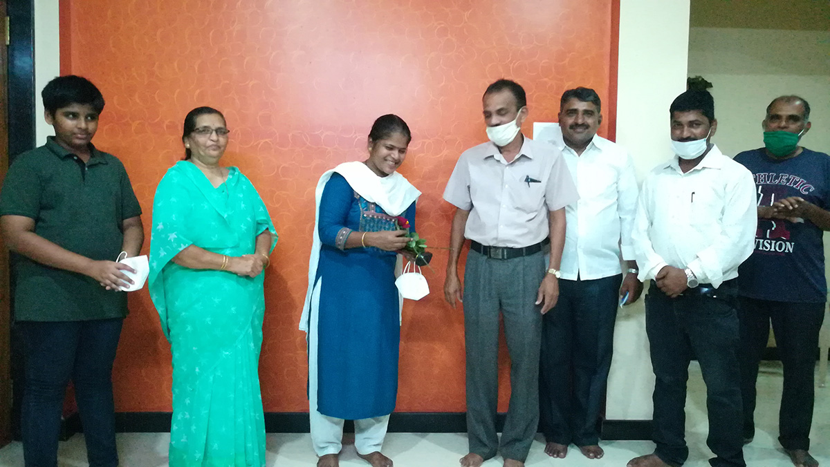 Flower being presented to Dr. Gayatri Kalyanshetty by Shantaram Desai, Treasurer. Also, seen in the photos are committee members of the association.