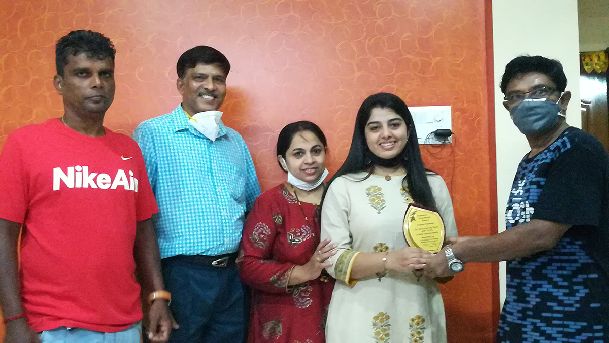 Award of Excellence presented to Anisha Tulaskar- for securing top rank with 79.3% in MSc. Bio- chemistry by Shri Valmiki Nayak. Also, seen in the photo are her parents and association committee member Yadvesh Gonge.