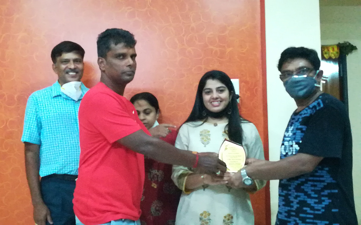 Award of Excellence presented to Anisha Tulaskar- for securing top rank with 79.3% in MSc. Bio- chemistry by Shri Valmiki Nayak. Also, seen in the photo are her parents and association committee member Yadvesh Gonge.