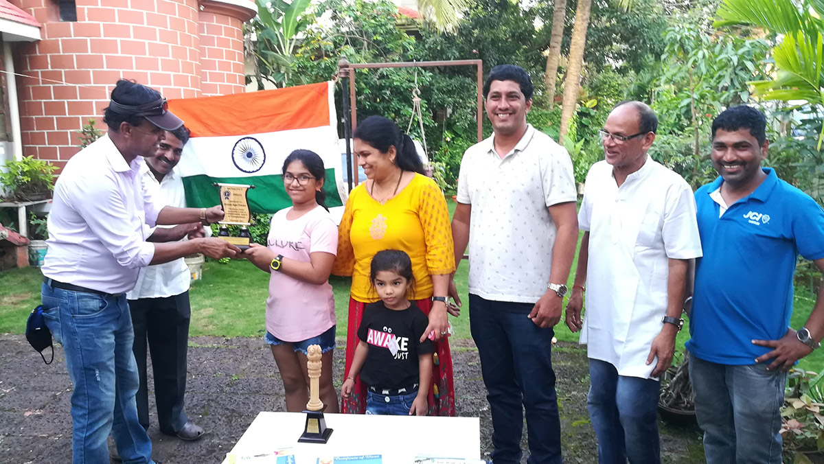 Winner of 1st Prize in age group 8 to 11 awarded to Miss Shreesha Sagar Toraskar for excellence in the Fancy dress competition held on 15-Aug-2021. <a href=https://youtu.be/f4lS5Cnda_4 target=_blank class=blue>View competition video</a><br><br>

Seen in the photo (from left): Shri Wilfred Fernandes presenting prize to Miss Shreesha Sagar Toraskar, Shri Monish Meti (background), Smt Sagar Toraskar, Miss Dhanisha Toraskar (foreground), Shri Sagar Toraskar, Association President Shri Santosh Desai and Association Secretary Shri Ganesh Lamani