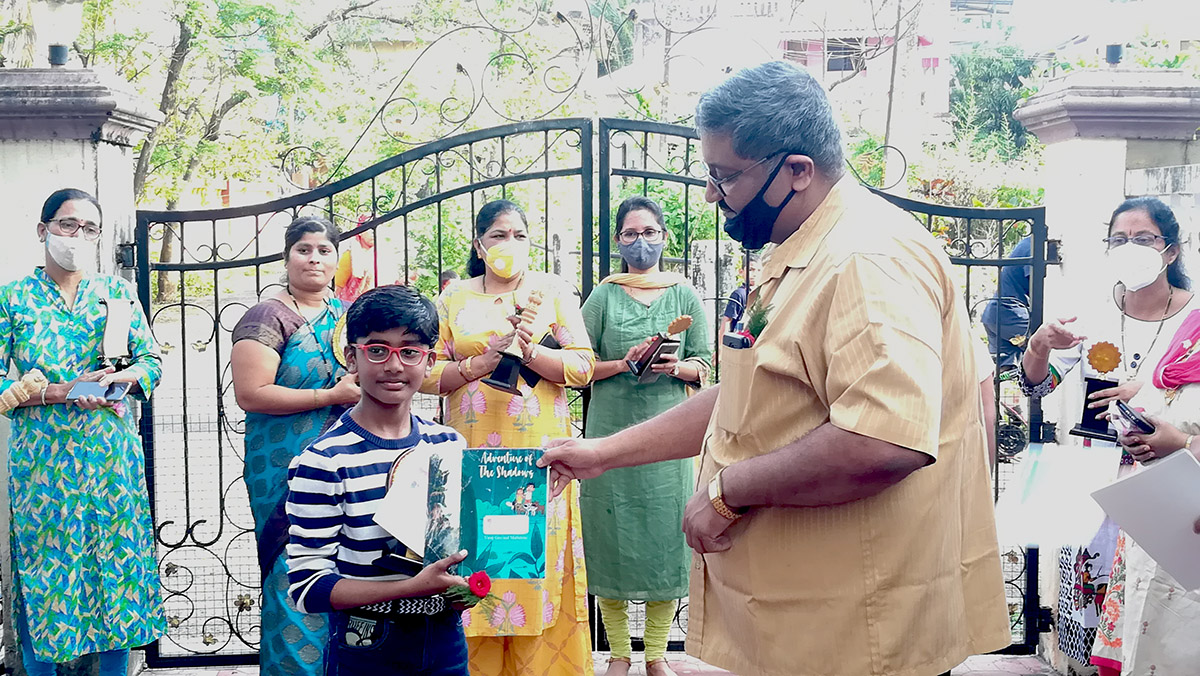 Winner of 2nd Prize in age group 8 to 11 awarded to Master Ayaan Nazim Khan for excellence in the Fancy dress competition held on 15-Aug-2021. <a href=https://youtu.be/bkxxG9THUkw target=_blank class=blue>View competition video</a><br><br>

Seen in the photo (from left): Smt Shantaram Desai, Smt Monish Meti, Professor Viraj Govind Mahatme seen presenting a set of books authored by him to Master Ayaan Nazim Khan. In background is Smt Uma Desai, Smt Praveen Shrungare and Smt Tejal Nayak.