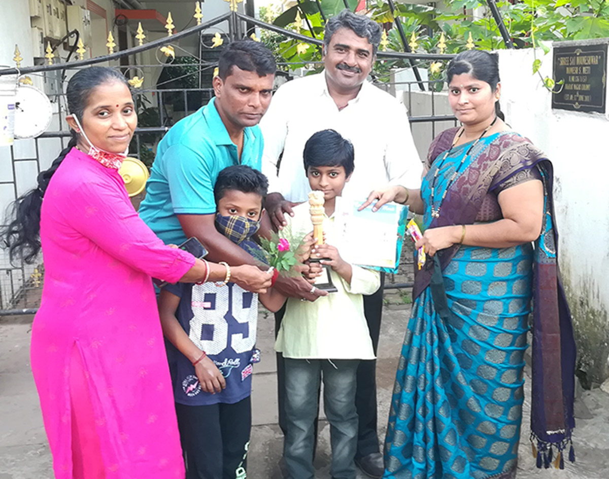 Winner of 3rd Prize awarded to Pavan Monesh Meti ( age group 4 to 7 ) for excellence in the Fancy dress competition held on 15-Aug-2021. <a href=https://youtu.be/phtqvdzLD0Y target=_blank class=blue>Competition Video</a><br><br>
Seen in the photo (from left): Smt Yadvesh Ghonge, Master Ghonge,  Shri Yadvesh Ghonge seen presenting the certificate to Master Pavan Monesh Meti,  Shri Monesh Meti and Smt Monesh Meti (background).