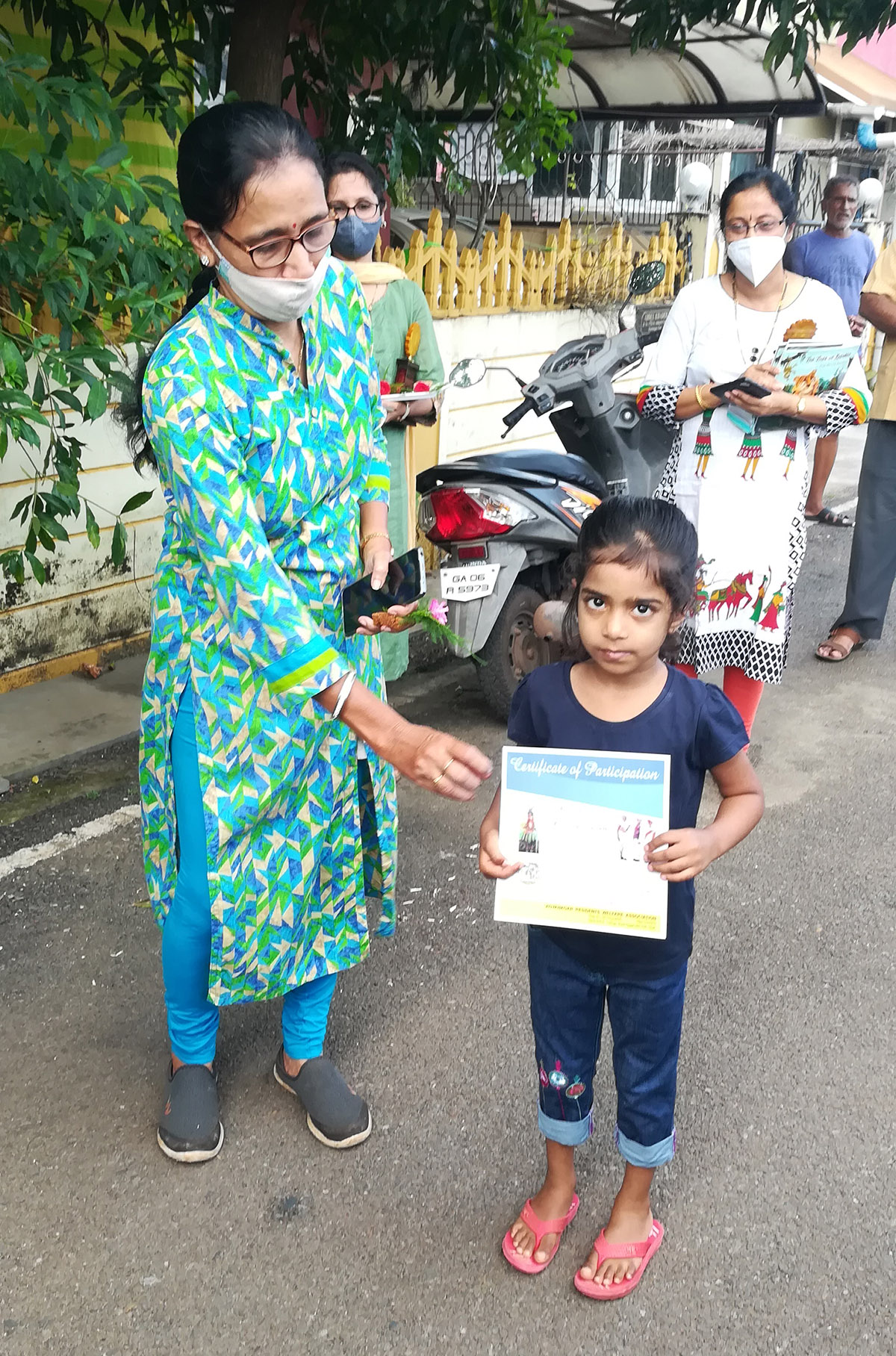 Award of participation certificate to miss Yusra Salim Shaikh for participating in the Fancy dress competition held on 15-Aug-2021. <a href=https://youtu.be/DLx0uS7wtg0 target=_blank class=blue>Competition Video</a><br><br>
Seen in the photo (from left): Smt. Shantaram Desai presenting the certificate to miss Yusra Salim Shaikh, Smt Praveen Shrungare and Smt Tejal Nayak (background).