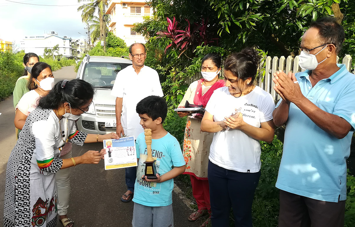 Co-winner of 3rd Prize in age group 4 to 7 awarded to Shray Nirmesh Naik for excellence in the Fancy dress competition held on 15-Aug-2021. <a href=https://youtu.be/SnOEOYULueQ target=_blank class=blue>View competition video</a><br><br>
Seen in the photo (from left): Smt Tejal Nayak presenting the certificate to Shray Nirmesh Naik, Smt Luiza Correia and Smt Praveen Shrungare (background), Association President Shri Santosh Desai, Smt. Vijayshri B. Gunjikar, Smt Mithila Naik, grandfather Shri Vaman Naik.