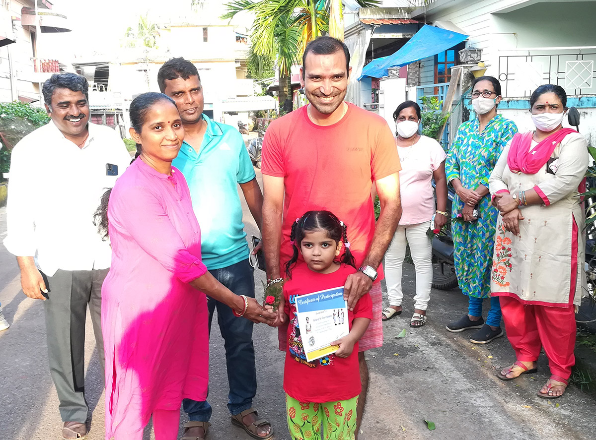 Award of participation certificate to miss Ahana M Pai Vaidya for participating in the Fancy dress competition held on 15-Aug-2021. <a href=https://youtu.be/7asIt0xWKfw target=_blank class=blue>Competition Video</a><br><br>Seen in the photo (from left): Smt Yadvesh Ghonge presenting certificate to Ahana M Pai Vaidya, Shri Monesh Meti and Shri Yadvesh Ghonge  (background), Shri Mayurish Vaidya, Smt Luiza Correia, Smt. Vijayshri B. Gunjikar and Smt. Vijayshri B. Gunjikar (background).