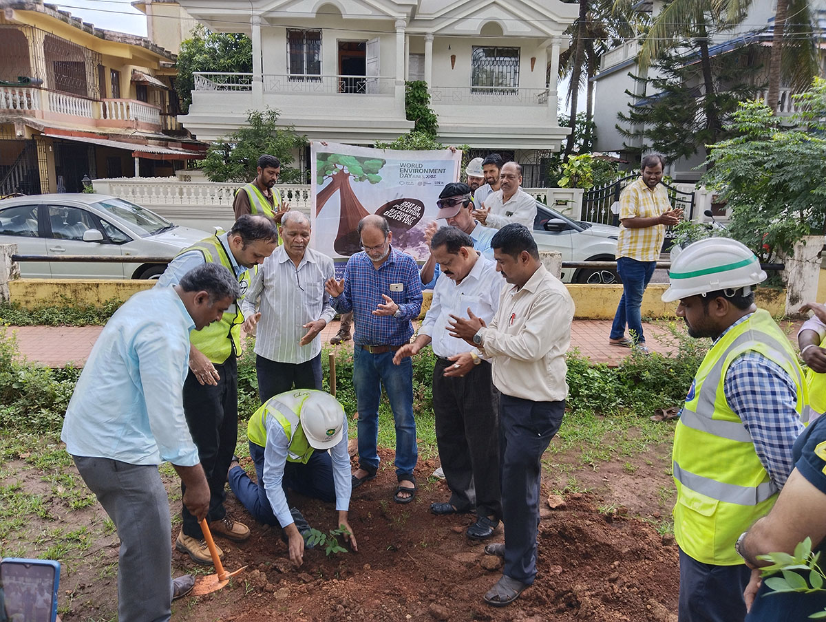 Seen here are Vidyanagar Residents Welfare Association; President Shri Monish Meti (left) while a member of the L&T team Shri Gurumurthy venkat Murty, planted a sapling. Looking on are Shri Rajaram Patil, Shri L.T Naik (white shirt foreground), ex_President Shri Santosh Desai (in Jeans),  Secretary Shri Ganesh Lamani, Shri Wilfred Fernandes (blue shirt) and other members of the L&T team which included Shri Jayant Prabhakar Gosavi, Project Manager,  L&T Ltd., Adora De Goa Project (in the background near the banner).