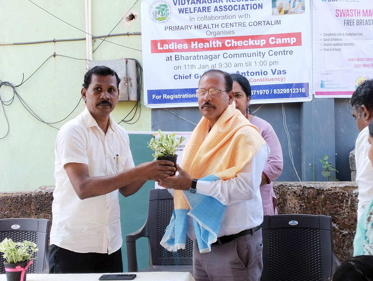 Chief guest Shri Antonio Vaz honoring Shri Ashok Kumar Das with a shawl and a plant for his contribution to the park in Bharatnagar.